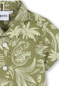Camicia a maniche corte con sfondo verde, motivi di foglie di palma bianche e iguane, dotata di colletto a camicia e etichetta del marchio.