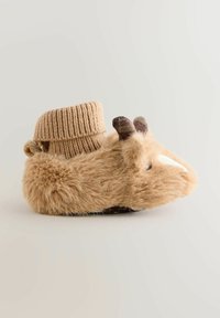 Pantoufle beige moelleuse avec un revers en tricot côtelé, de petites cornes et un détail de museau blanc, le tout reposant sur une semelle sombre contrastante.