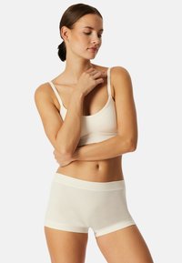 Hellbeige Bralette und Boyshort-Set, nahtloses Design, weicher Stoff, minimale Details, dünne Träger, elastischer Bund und bequeme Passform.