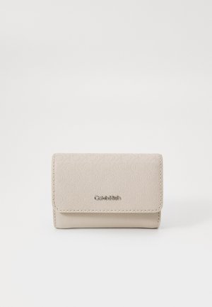 Beige faux leather wallet featuring an embossed geometric pattern, a flap closure, and a metallic logo detail on the front.