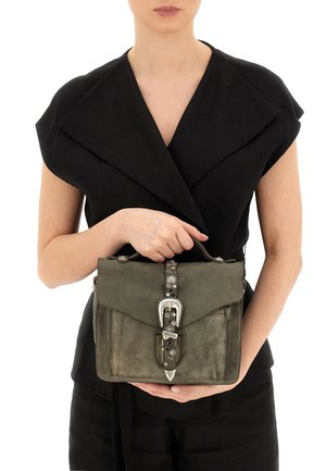 Borsa a tracolla in pelle grigia con patta, hardware argentato, chiusura con fibbia distintiva e borchie decorative sulla tracolla. Forma rettangolare strutturata.