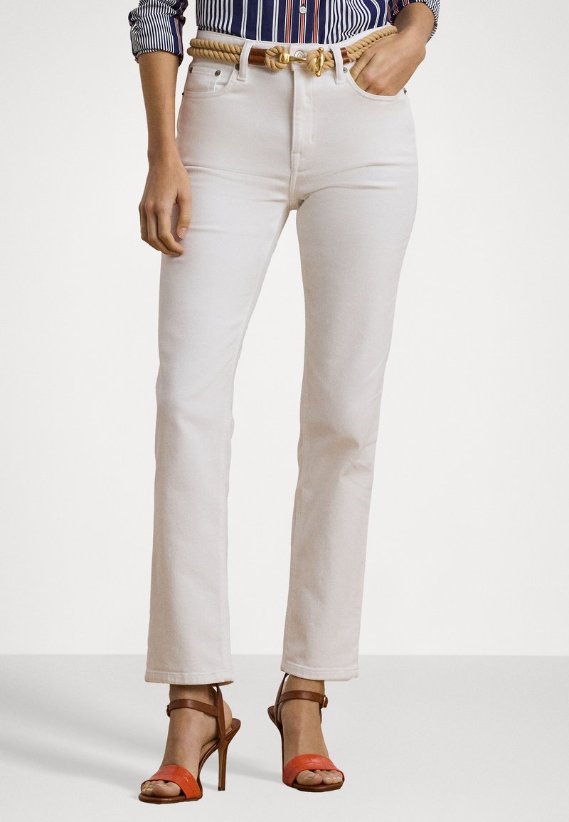 White denim straight-leg jeans with a high waist, featuring a braided tan belt and orange striped sandals. Smooth texture and clean design.