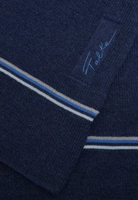 Tessuto a maglia blu marino con strisce azzurro chiaro e grigio. Etichetta rettangolare con "Falke" ricamato in azzurro chiaro. Texture morbida.