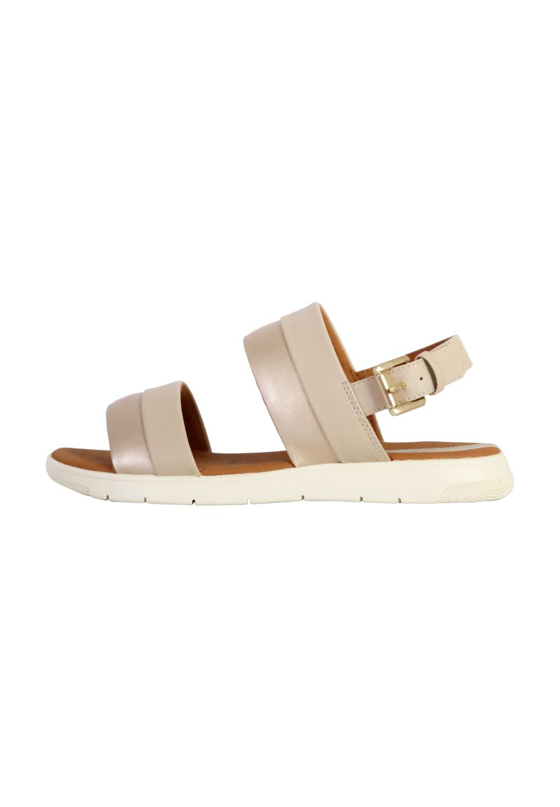 Sandaña de cuero beige con dos correas anchas y hebilla en el tobillo. Presenta una plantilla acolchada y una suela de goma blanca con agarre texturizado.