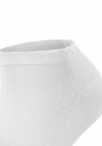 Biała skarpetka za kostkę wykonana z teksturowanej bawełny, z prążkowanym wykończeniem u góry i małym wzorem kropek na powierzchni. Gładkie wykończenie materiału.
