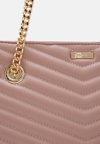 Gewatteerde roze leren handtas met een gouden kettingriem, verfraaid met een ronde metalen detail en een logo-plaatje.