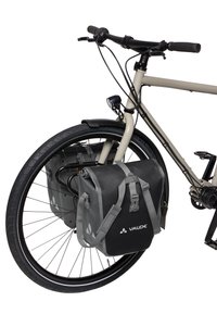 Voorkant van een beige fiets met zwart stuur, voorwiel, licht en een bevestigd zwart Vaude fietstas.