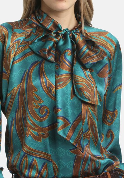 Zijde blouse in teal met een bruin en blauwe draai patroon. Heeft een nekband en een zachte, gladde textuur. Lange mouwen met gathers op de schouders.
