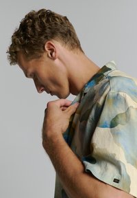 Korte mouwen, knoopsluiting shirt in een lichte, gestructureerde stof met abstracte patronen in blauw, groen en beige. Beschikt over een kraag en een ontspannen pasvorm.