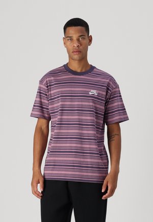 Camiseta de manga corta a rayas en tonos de rosa y morado, con un cuello redondo y un pequeño logo blanco de Nike en el pecho.