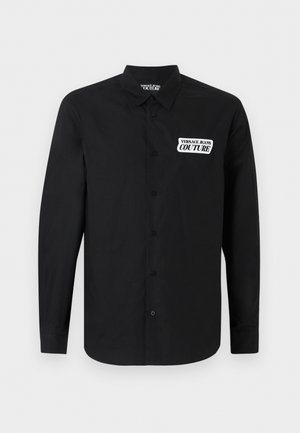 Zwart overhemd met lange mouwen en knopen, met kraag, voorzien van een witte patch op de borst en een label binnenin de kraag met de tekst "Versace Jeans Couture".