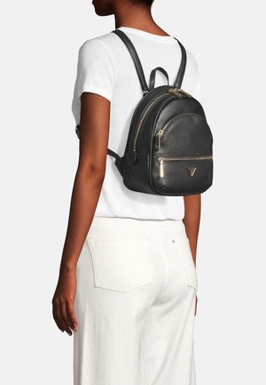 Sac à dos en cuir noir avec des garnitures dorées, sommet arrondi, double zip et poche avant. Porté sur le dos avec des bretelles réglables.