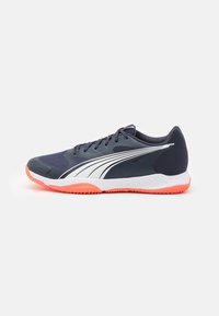 Baskets de sport avec un dessus bleu marine, des accents blancs et une semelle orange. Comporte un matériau en mesh et une surface texturée pour une meilleure adhérence et un soutien optimal.
