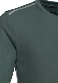 T-shirt de sport vert foncé avec une surface texturée, un col arrondi et des coutures gris clair le long des épaules.