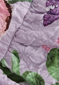 Fialová tkanina s květinovým vzorem, na kterém jsou růžové květy a zelené listy, s nasbíranou texturou a jemným leskem.