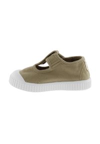 Zapato de lona color beige con una puntera de goma blanca y suela texturizada. Presenta un diseño con cortes y una correa de velcro para facilitar su uso.