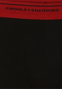 Zwarte boxer shorts met een rode elastische tailleband waarop in zwarte tekst "FINSHLEY & HARDING" staat. Glad materiaal met een strakke pasvorm.