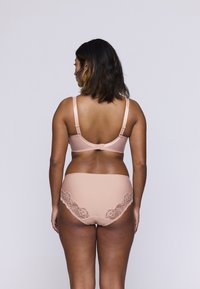 Nagie biustonosz i pasujące majtki z koronkowym wykończeniem, wykonane z gładkiego materiału i z regulowanymi ramiączkami, pokazujące widok z tyłu oraz ogólny projekt.