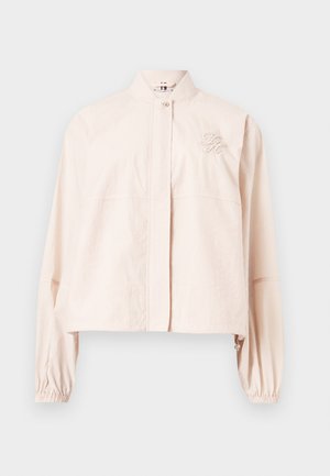 Veste courte rose clair à manches longues avec col montant, fermeture à pression devant, poignets élastiques et logo brodé sur la poitrine gauche.