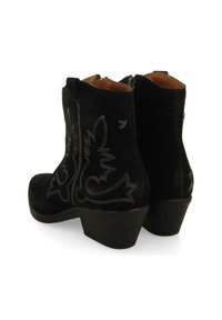 Botines de ante negros con un tacón ligeramente curvado, que presentan patrones bordados en blanco a los lados y una cremallera en la parte posterior para el cierre.