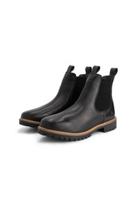Paar zwarte leren Chelsea-boots met bruine stiksels, elastische zijkanten, trekbanden en dikke profielzolen op een witte achtergrond.