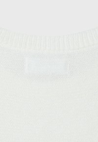 Gros plan sur l'encolure d'un pull blanc en maille avec une étiquette rectangulaire blanche vierge cousue à l'intérieur du col arrière.