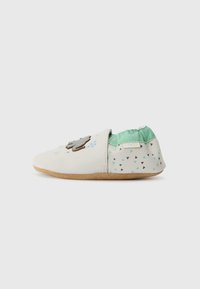 Mīksta balta āda slip-on kurpe ar pelēku mākoņu dizainu, piparmētru zaļa auduma odere un rakstainais papēdis, kas rotāts ar melniem un piparmētru zaļiem trijstūriem.