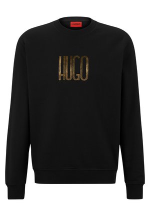 Czarna bluza z długim rękawem i okrągłym dekoltem z napisem "HUGO" dużymi złotymi literami na środku klatki piersiowej oraz czerwoną metką wewnętrzną na karku.