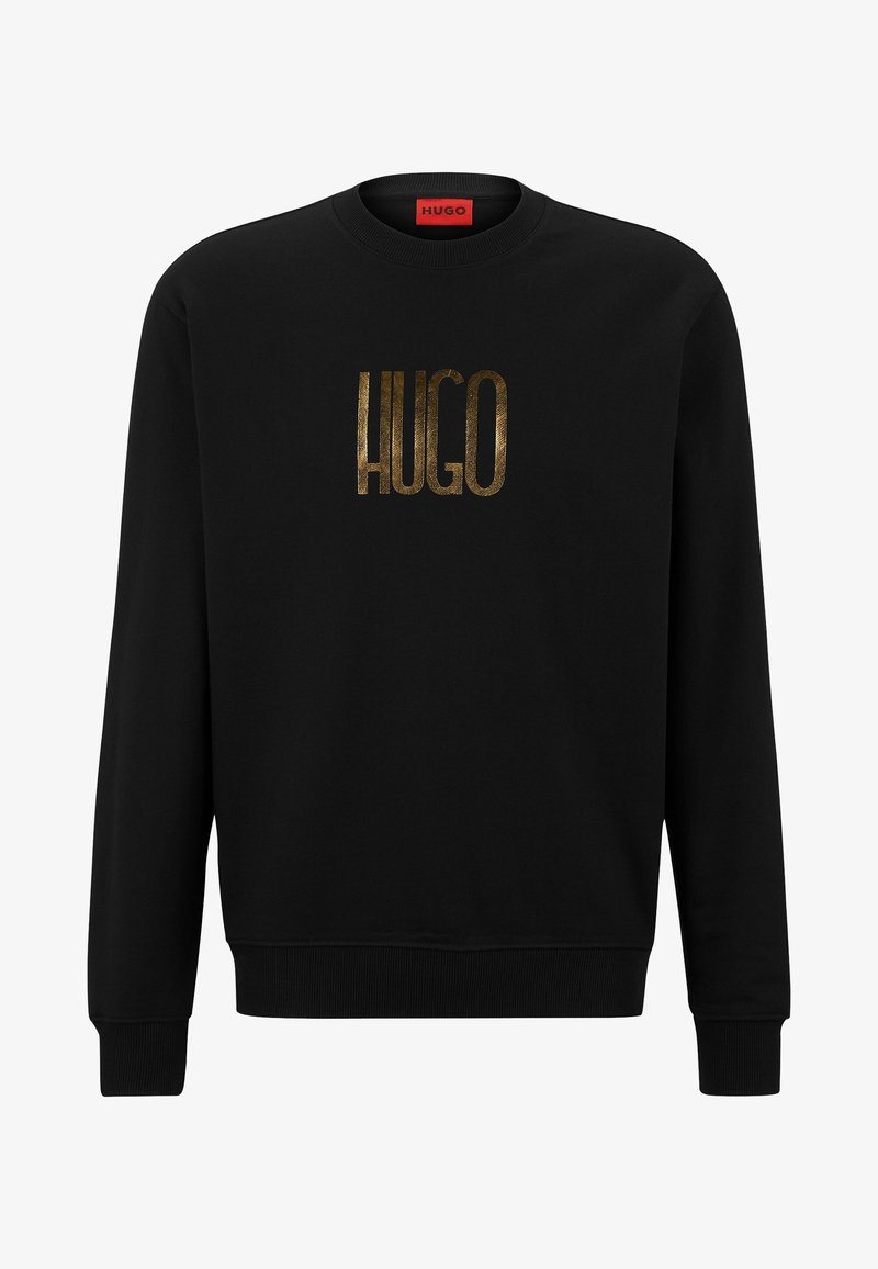 Sweat-shirt noir à manches longues col rond avec "HUGO" en grandes lettres dorées centrées sur la poitrine et une étiquette rouge à l'intérieur du col.