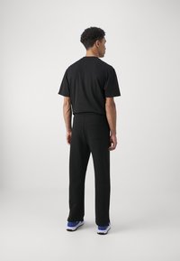 HUGO NANETTI - Pantalones deportivos - black