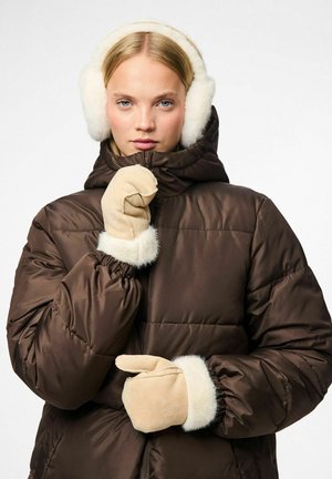 Bruine pufferjack met een bontgevoerd capuchon, aangevuld met beige handschoenen met bontmanchetten. Gladde textuur en doorgestikt ontwerp overal.