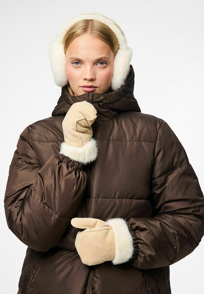 Veste matelassée marron avec capuche bordée de fourrure, accompagnée de gants beiges avec des poignets en fourrure. Texture lisse et design matelassé sur l'ensemble.