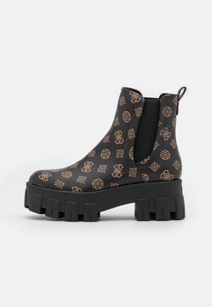 Schwarzer Knöchelstiefel mit klobiger Sohle, hellbraunen gemusterten Logos, elastischen Seitenpaneelen und Zuglasche hinten, gezeigt vor weißem Hintergrund.