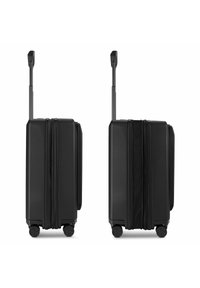 Maleta rígida negra con asa telescópica, dos ruedas y diseño texturizado, con compartimentos laterales con cremallera.