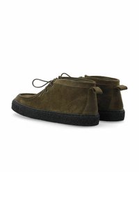 Scarpe alla caviglia in suede verde con suola testurizzata nera, dotate di lacci e linguetta posteriore per una facile calzata. Superficie liscia e design curvo.