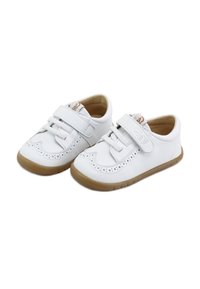 Un par de zapatos blancos para niños pequeños con suelas de goma marrón, que cuentan con correas de Velcro y perforaciones decorativas en la parte superior.