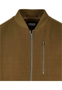 Veste bomber marron avec col côtelé, fermeture éclair centrale argentée, poche poitrine verticale zippée et étiquette "Urban Classics" à l'intérieur du col.