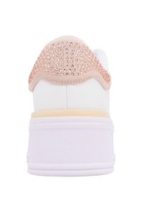 Sneaker bianco con tallone in suede rosa testurizzato, accentuato da piccoli chiodini in oro rosa. Suola bianca spessa con un motivo sottile, branding minimale visibile.