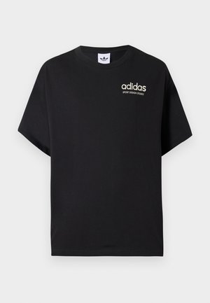 T-shirt di cotone nero con maniche corte, caratterizzata da un collo rotondo e logo Adidas bianco con "SPORT DESIGN STUDIO" in oro. Texture liscia.