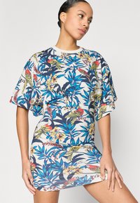 Φόρεμα με κοντά μανίκια που διαθέτει τροπικό φλοράλ και πουλιά σε ζωηρό μπλε, κόκκινο και κίτρινο σε ανοιχτό φόντο. Καθημερινή, άνετη εφαρμογή.