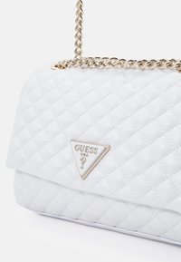 Borsa a spalla bianca trapuntata in materiale sintetico, con una tracolla a catena dorata e una placca del logo in metallo a forma triangolare sul fronte.