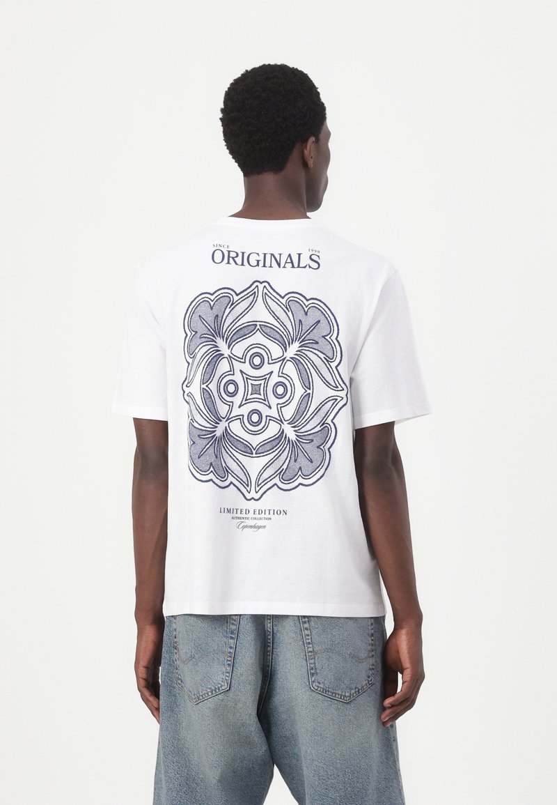 Camiseta de algodón blanca con un gran diseño gráfico azul en la parte posterior, con el texto "EDICIÓN LIMITADA" y "ORIGINALS" arriba y abajo de la obra.