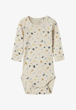 Body z długim rękawem w jasnobeżowym kolorze z kwiatowymi i ważkowymi wzorami w kolorach żółtym, niebieskim, czarnym i różowym. Miękka tkanina z zapięciem na zatrzaski u dołu.