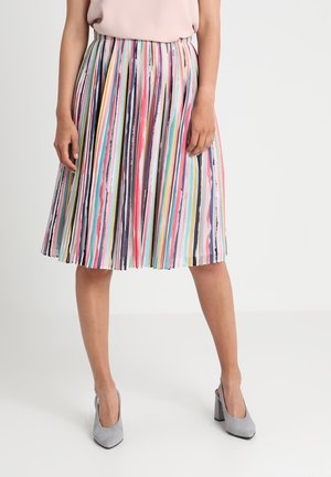 Woman wearing a pleated midi skirt with vertical multicolor stripes and light gray high-heeled shoes against a plain background.