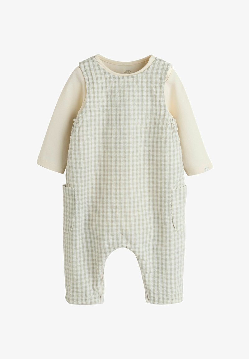 Grenouillère bébé manches longues beige et blanche avec motif à carreaux et poches latérales, en tissu doux pour le confort et la chaleur.