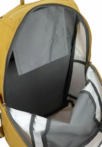 Mochila amarilla con un interior gris, que cuenta con múltiples compartimentos y correas ajustables. El material es duradero y está diseñado para el orden.