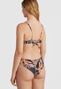 Gėlių rašto bikini su juodu pagrindu, reguliuojamu viršumi su raišteliu ir atitinkančiomis kelnaitėmis, dekoruotomis spalvingais tropiniais lapais.