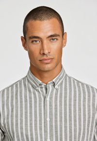 Lichtgroen en wit gestreepte button-up shirt met een kraag, met een linnenachtige textuur en een standaard knoopsluiting.