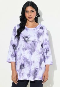 Top a maniche lunghe con stampa tie-dye viola e bianca, scollo rotondo e dettagli decorativi. Tessuto morbido e vestibilità rilassata.