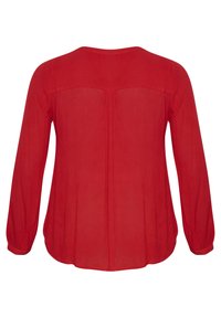 Blusa roja de manga larga con una textura suave, que presenta un escote redondo, detalles fruncidos en la parte posterior y puños abotonados.